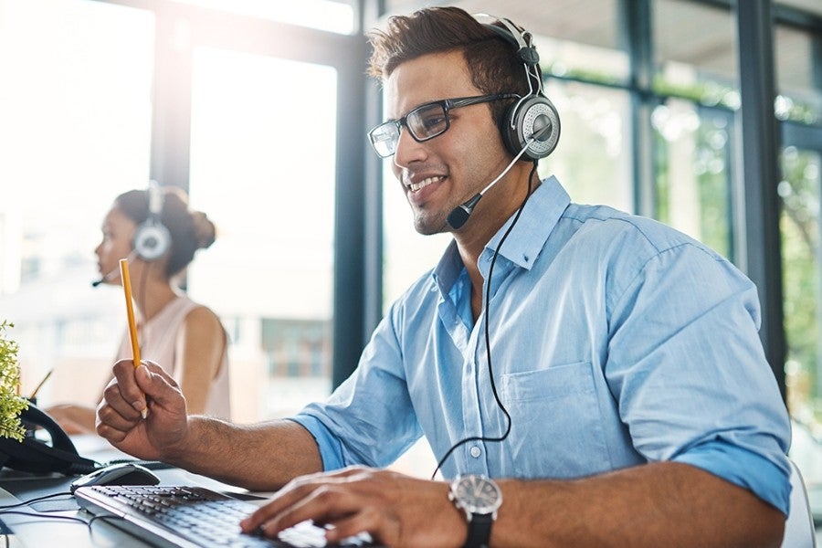 Customer support agent wearing headset at desk
